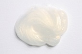 Blob of white shiny hair styling product on white background, close-up