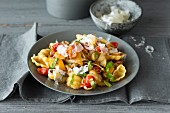 Pasta shells with tomatoes, olives, peppers and bacon