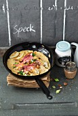 Bacon pancakes with pears and hazelnuts in a pan