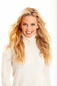 Portrait of beautiful blonde woman wearing white turtleneck sweater, smiling