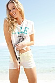 Blonde, sporty woman with long hair in a T-shirt on the beach