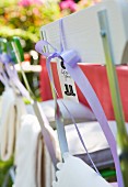 A name tag tied to a garden chair with a ribbon