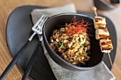 Risotto with saffron and skewer in bowl