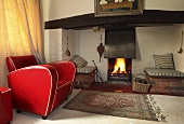 A red leather armchair in front of a fire
