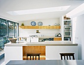 White designer kitchen with kitchen unit under a skylight in contemporary architecture