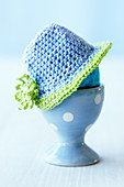 An Easter egg with a crocheted hat in an egg cup