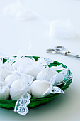White eggs with lace ribbons in a bowl