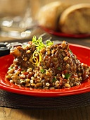 Braised knuckle of lamb with aubergines and barley