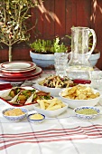 Falafel, pasta salad, crisps and dips for a picnic