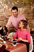 A couple eating Christmas dinner in a vaulted cellar