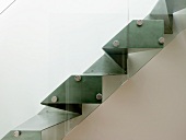 Seitenansicht einer massgefertigten Treppe aus Metall mit Glasgeländer