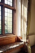 Custom upholstered window seat with leaded window