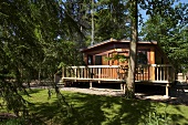 Wooden weekend house with veranda in the forest