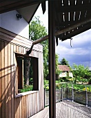 Detail of a home with wooden terrace and view of the garden