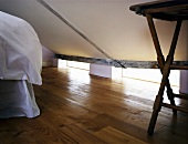 Sleeping area under a pitched roof and old wooden floor