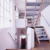 Stairwell with stairs leading off into another location and view into an open living room