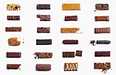 Large Assortment of Granola Bars on White Background; Some Crumbled and Bitten