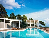 Pool in front of contemporary white villa in a Mediterranean landscape