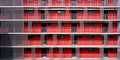 Wohnhaus mit Laubengängen an roter Fassade