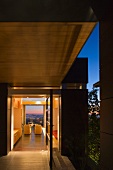 Evening mood on a terrace in contemporary architecture with an open door and view of an armchair