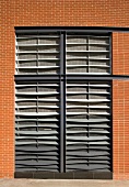 Ceiling high windows with closed blinds in a home's clinker brick facade