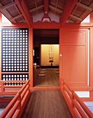 Traditionelles japanisches Wohnhaus mit hellrot lackierter Tür und Blick auf Bodenkissen