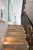 A flight of stone stairs with a black wrought iron banister