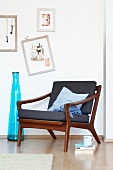 60s armchair in Danish design next to a blue floor vase and pictures on the wall