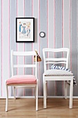 Vintage chairs upholstered with new fabric in front of striped wall paper