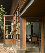 Traditional Indian house with wood and glass facade and open door with view into terrace
