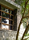 Natursteinfassade eines Wohnhauses mit modernem Sprossenfenster