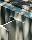 Detail of white painted metal support and concrete wall