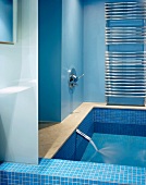 Light blue modern bathroom and full bathtub with running water