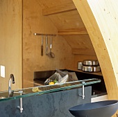 A glass-topped bar and a kitchen built into a wooden niche