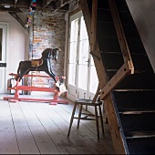 Vorraum mit einem Holzschaukelpferd und Holztreppe