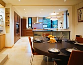 A Bauhaus pendent lamp hanging above a laid dining table in a modern open-plan kitchen