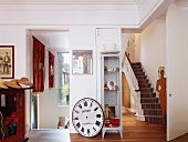 Collectors' items in foyer of renovated villa with view of stairs through open doorway