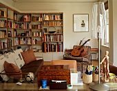 Youthful living room in natural colours with bookcases, guitar and artist's mannequin next to modern table lamp with transparent shade