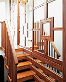 Schmale Holztreppe entlang aufwendig holzgerahmten Spiegel-Schiebetüren in englischem Wohnhaus