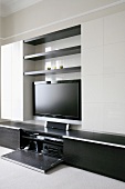 A modern living room cupboard with a flat screen television and a stereo cupboard
