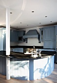 A curved kitchen counter with a sink in a country house-style kitchen