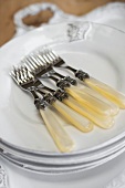 Forks on a stack of white plates