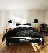 Frame of double bed and bedspread in black fur in white bedroom