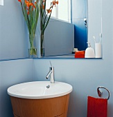 Modern washstand and mirror in corner of bathroom