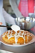 An exotic fruit cake being glazed with icing