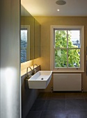 Schlichter moderner Badraum mit Waschtisch und Armatur unter Spiegelschrank