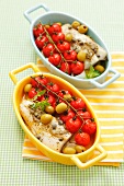 Halibut with cherry tomatoes, olives and capers in baking dishes