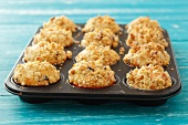Apple muffins topped with nut crumble in a muffin tin