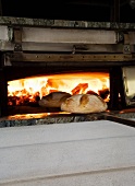 Bread being removed from a wood-fired oven