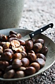 A bowl of chestnuts with a knife